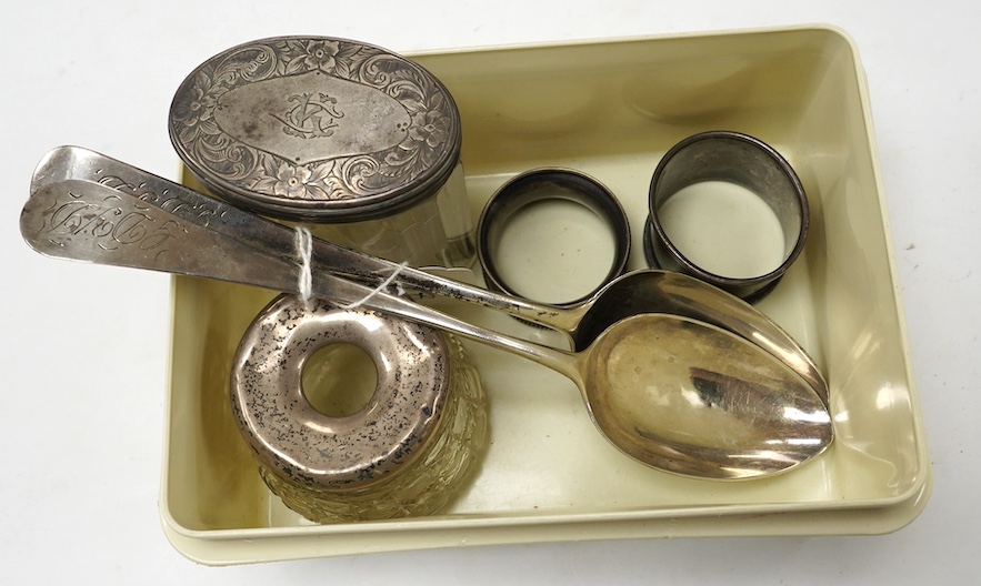 Two George III provincial silver Exeter table spoons, 22cm, two silver napkin rings and two silver mounted glass toilet jars. Condition - poor to fair